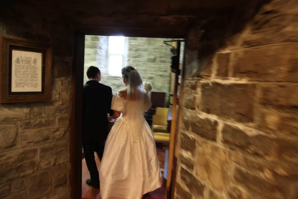 Bride and groom entering a stone chapel