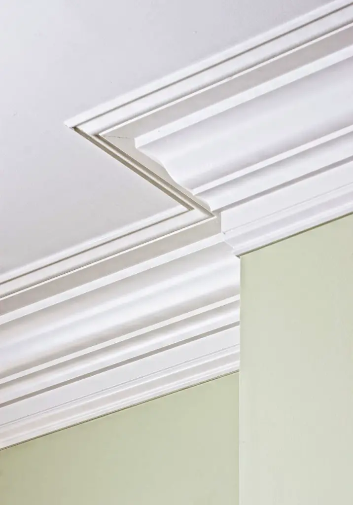 Elegant white crown moulding on green wall