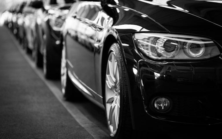 Close-up of parked black car in row.