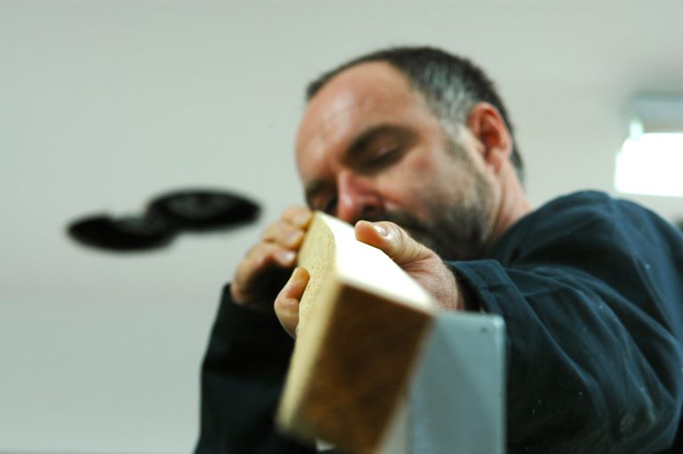 Carpenter examining wooden plank closely