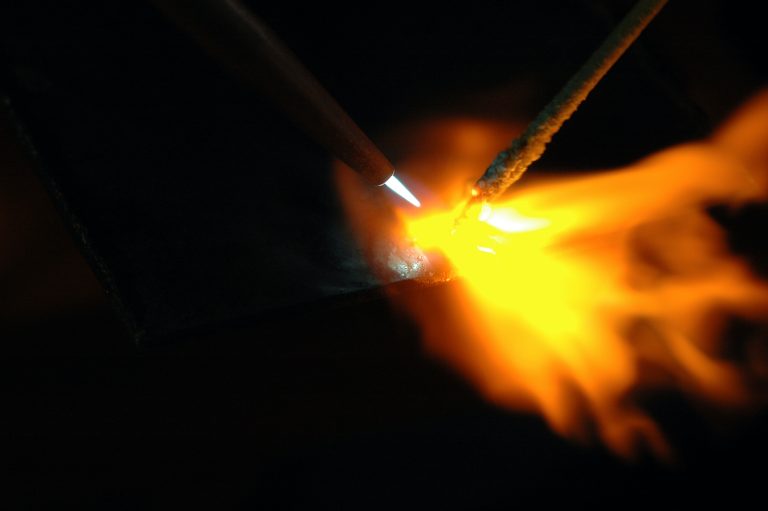 Close-up of welding flame and metal surface.