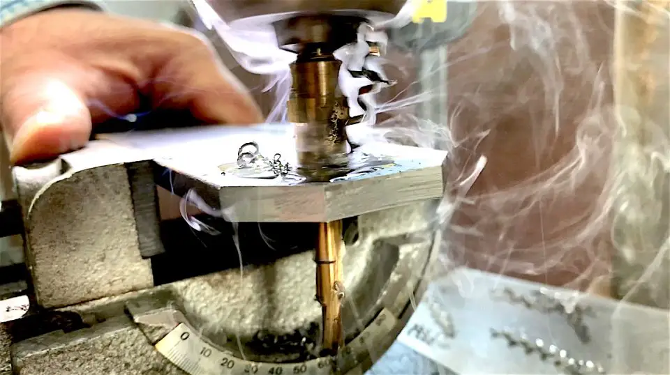Here I am using a step bit to bore a large hole in 1/4″-thick mild steel