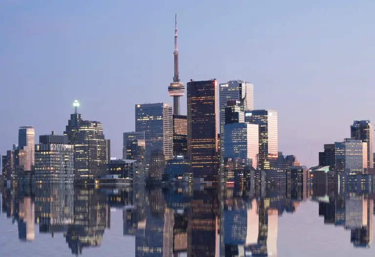 Toronto skyline reflected in water at dusk.