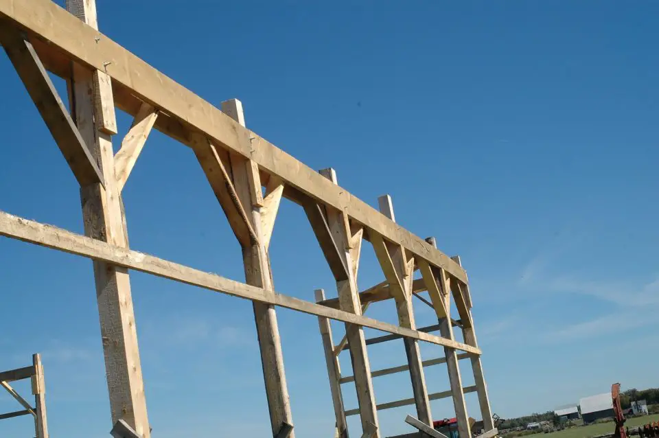 Notice how the top ends of the posts extend higher than the horizontal beam boards? These boards, once set level, act as a visual guide for trimming the posts to final length with a chainsaw.