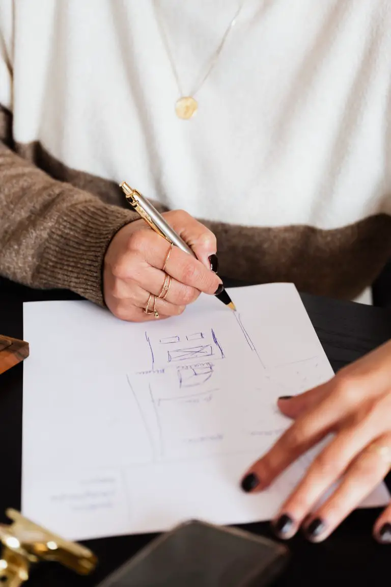 Person sketching on paper with a pen.