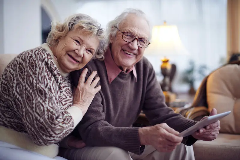 Happy elderly couple sitting and smiling together.