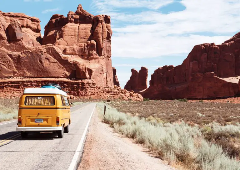Yellow van driving through desert canyon road