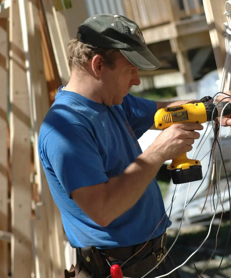 Electrician using drill on construction site