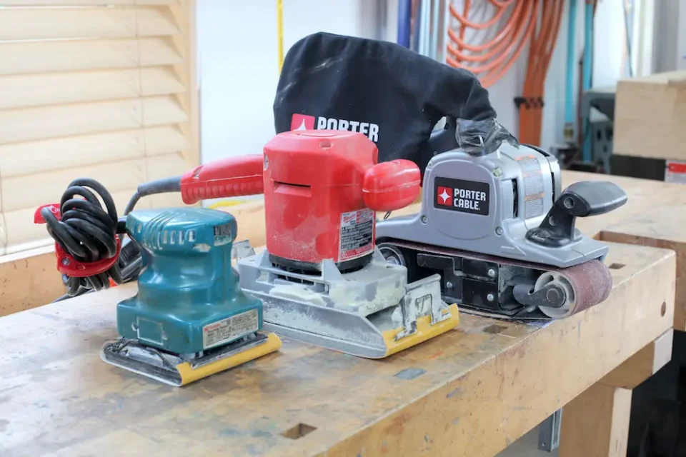 My three favourite woodworking sanders. The belt sander (right) is best for removing large amounts of wood as an initial sanding step; the half-sheet sander (middle) is a good next step machine after the belt sander; the quarter-sheet finishing sander (left) is the ideal final sanding tool and for sanding between coats of finish