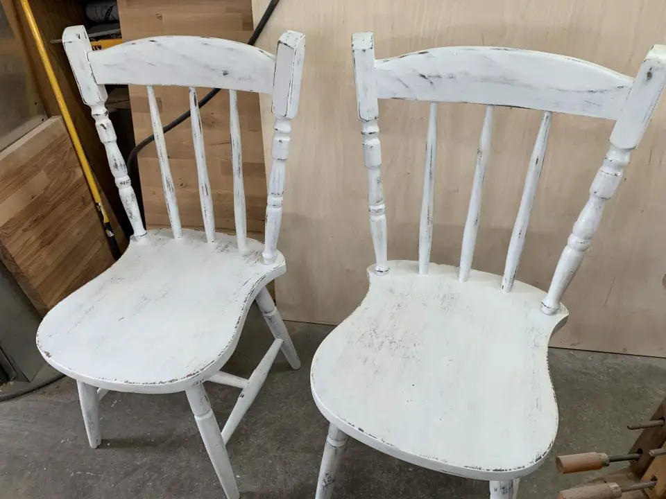 These matching chairs had chalked paint applied directly over an old, failing finish. A synthetic abrasive pad  or 220-grit sand paper is the best option for smoothening the dried paint and for rubbing through to reveal dark wood to simulate wear.