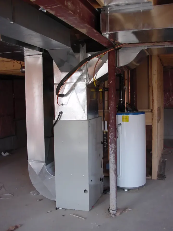 A typical forced air, natural gas furnace installed in a new house. Many modern gas furnaces are so efficient they need no chimney, they just vent out a wall via a plastic pipe.