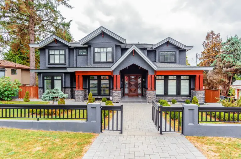 Modern grey house with red accents and front yard.