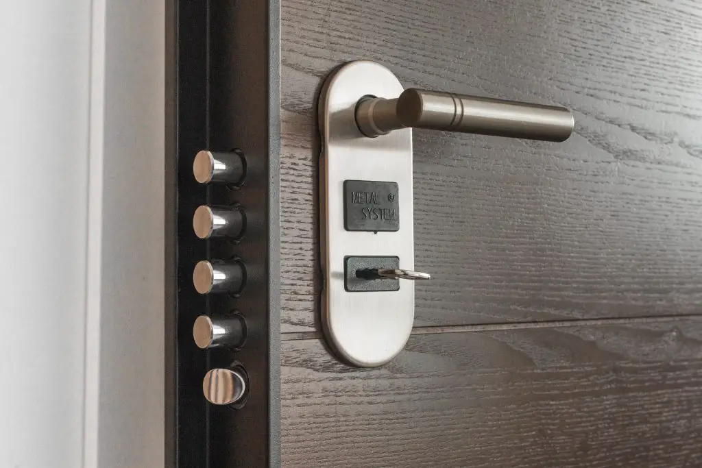 Stainless steel door lock with key inserted.