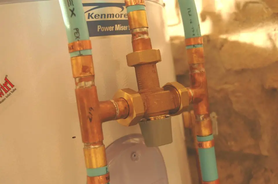Fully hot water enters the mixing valve on the left, before being combined with a controlled amount of cold water from the right. Output temperature is controlled with the grey knob on the bottom.