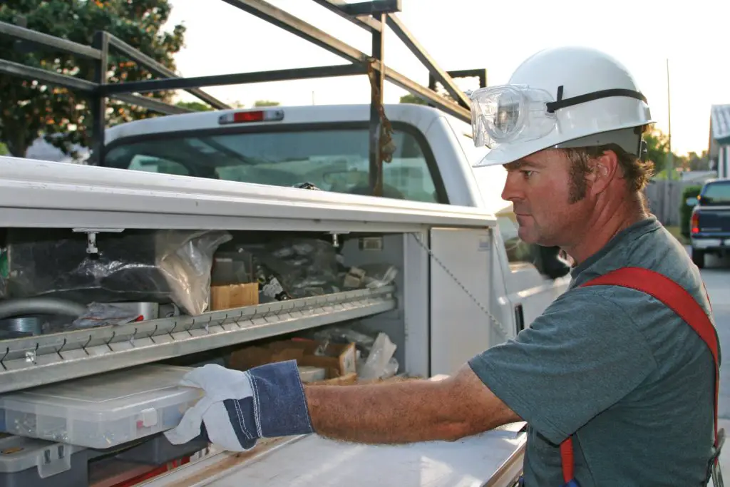 tradesman pulling a parts tray from a truck