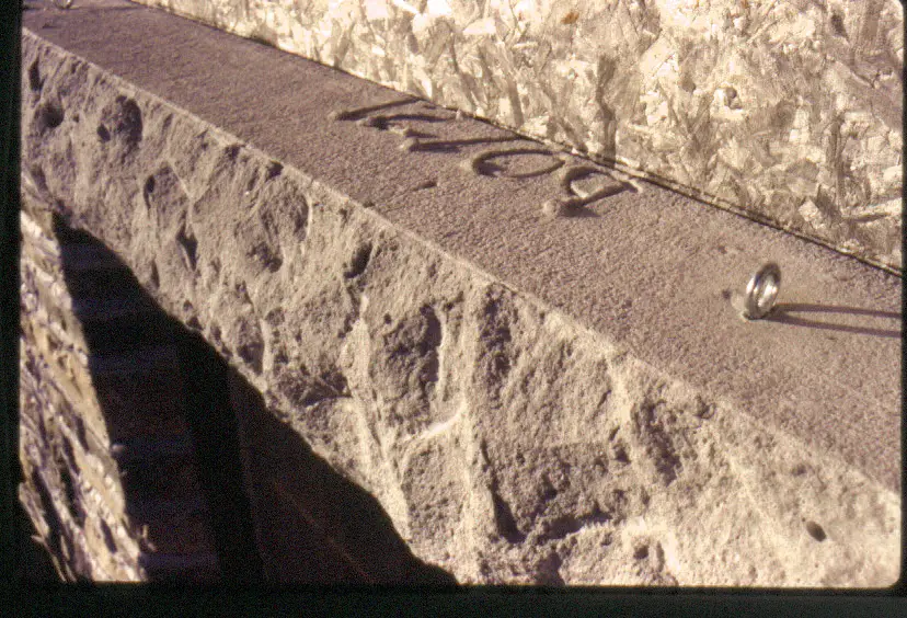 The cast, chiseled and installed window lintel made with a plywood form. The eyebolts in the top surface were cast into the lintel to make lifting and installation easier.