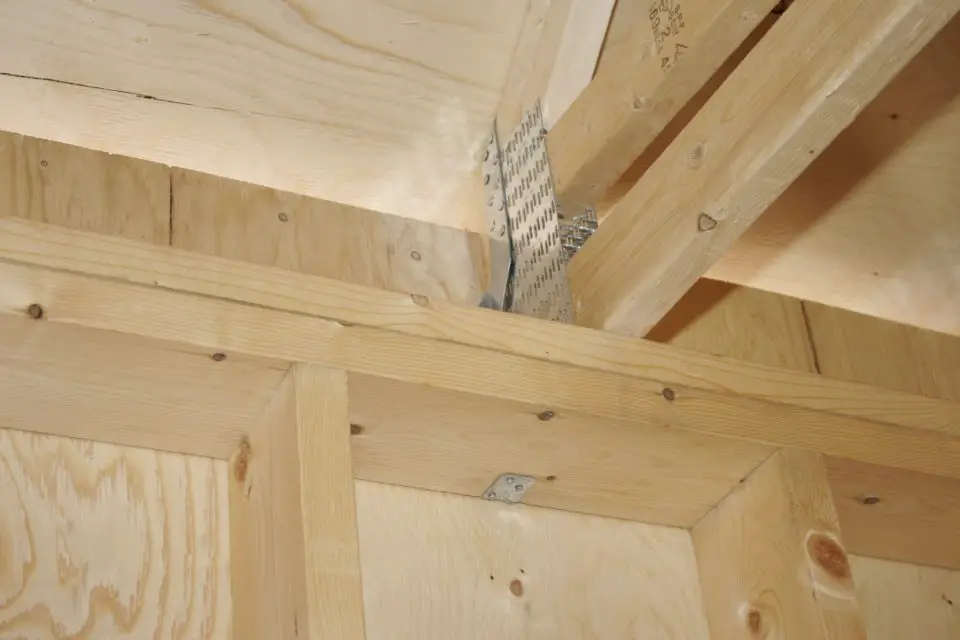 Notice how the metal hurricane tie securing the roof truss hooks down and around the underside of the wall plate. Little things like this can make all the difference in bad weather.