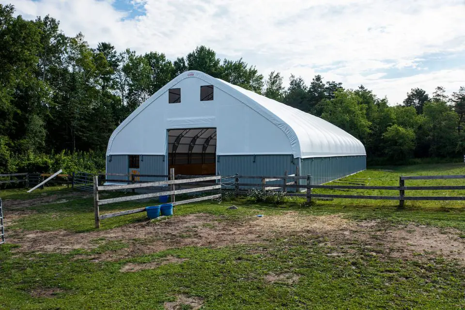Spacious barn with white roof in countryside.