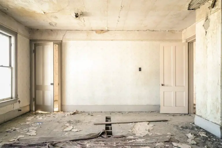 Empty, worn-out room with peeling walls and ceiling.