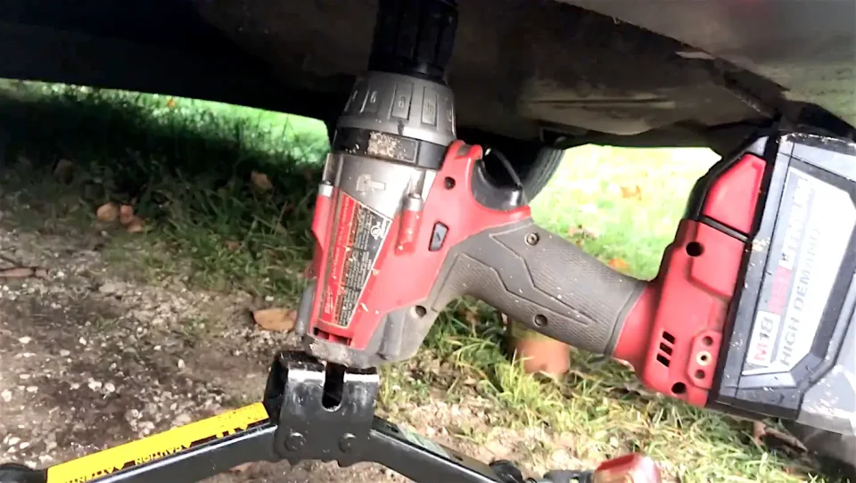 Cordless drill operating under a vehicle