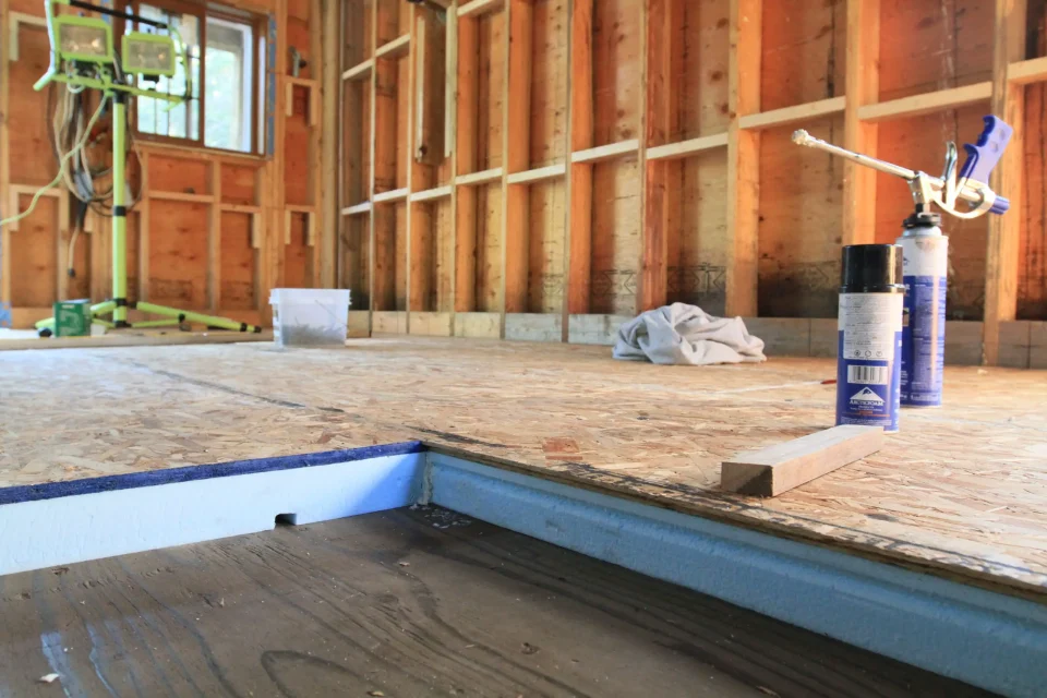 Wooden floor insulation installation in unfinished room