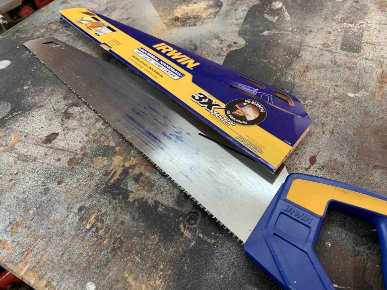 Irwin hand saw on rustic workbench.
