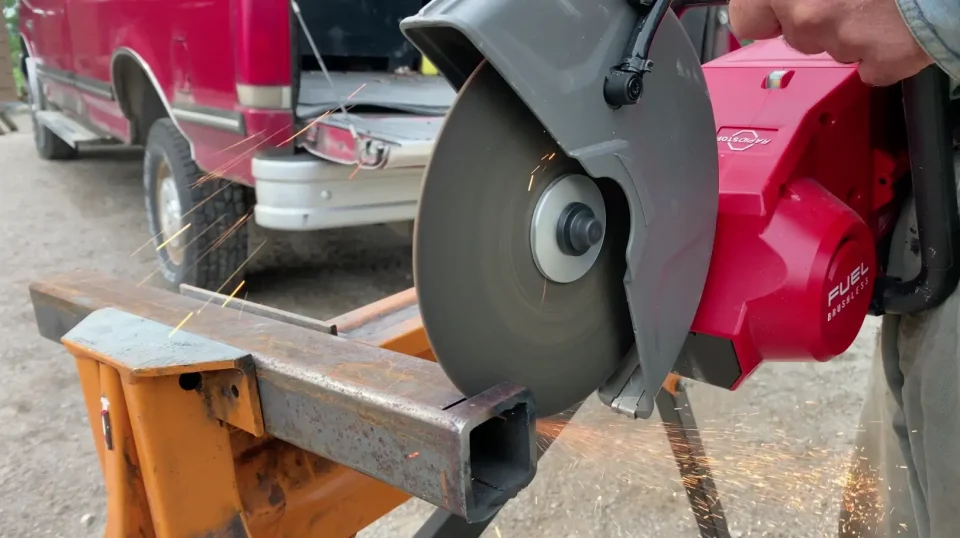 Chop saw cutting metal, sparks flying.