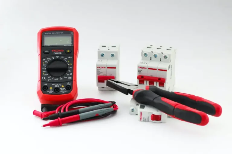 Digital multimeter, pliers, and circuit breakers on table.