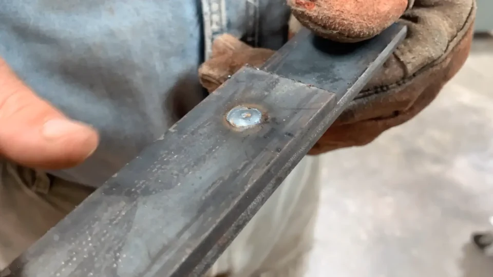 Close-up of metal piece with MIG tack weld.