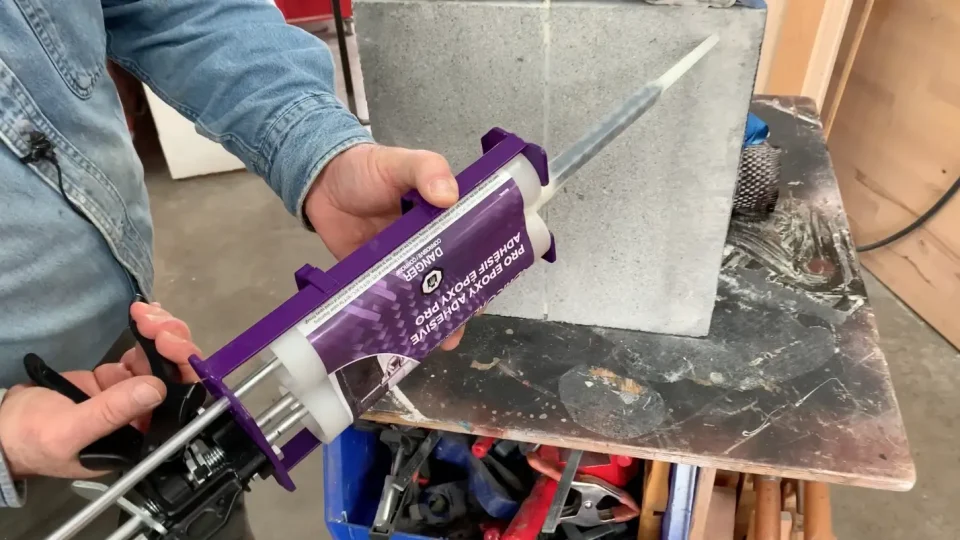 Applying epoxy adhesive to concrete block