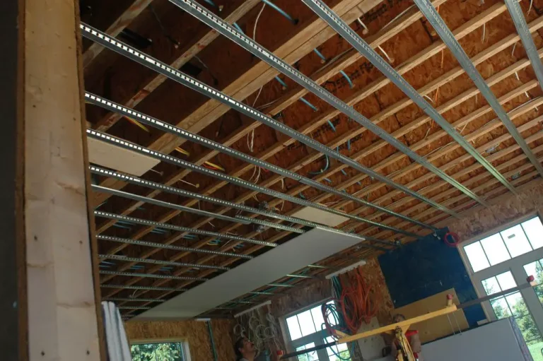 Open ceiling with exposed beams and wires.