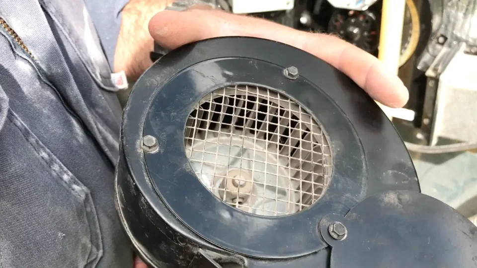 Person holding black metal machine part.