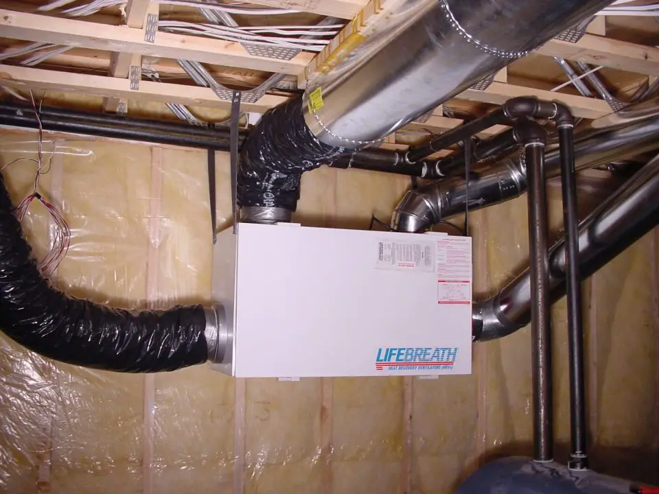 Basement ventilation system with ducts and pipes.