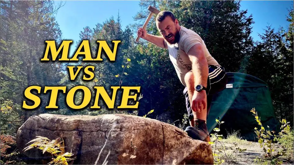 Man breaks stone with hammer in forest