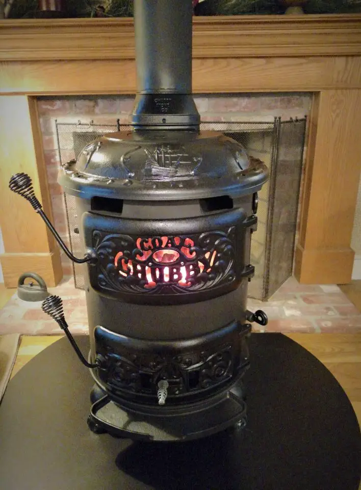 Black vintage wood stove with glowing embers.