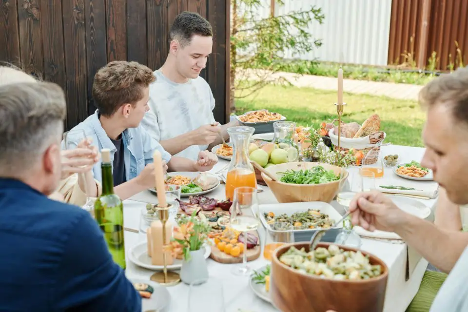 family eating food on a table outside