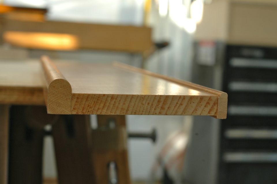 This is an end view of simple door trim made with two different shop-milled bullnose profiles flanking a flat piece of wood.