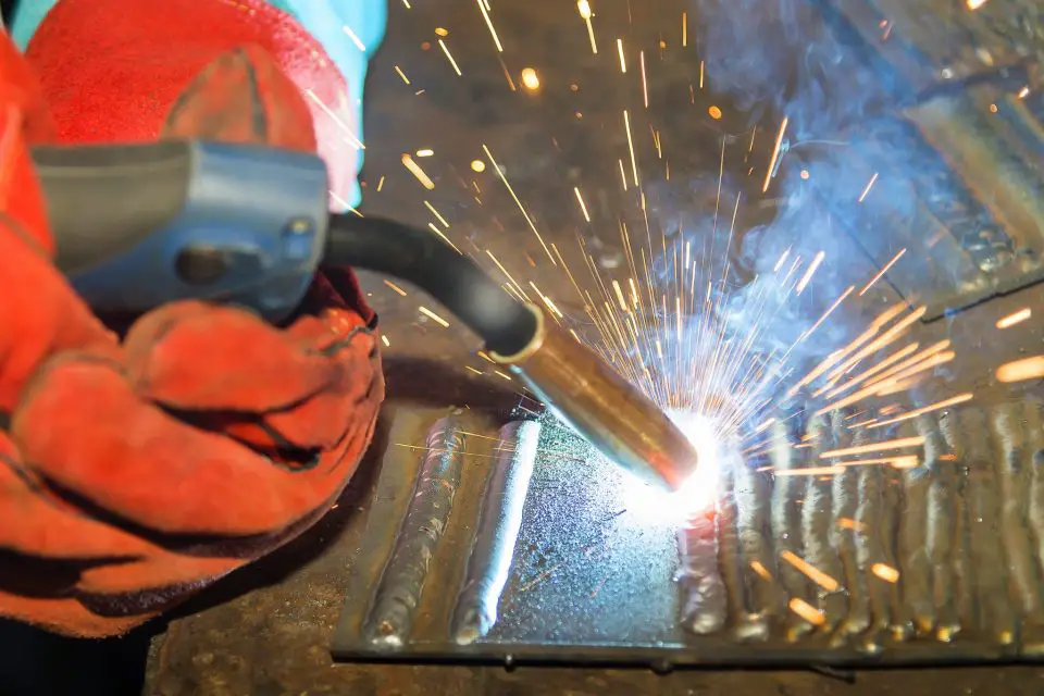 Practice beads of weld (to the right of the gun( build up as this sample metal gets multiple passes as a student perfects their details.