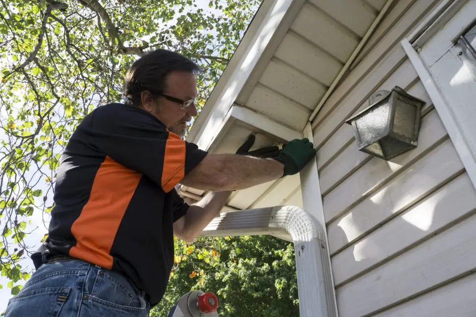 contractor inspecting exterior of house