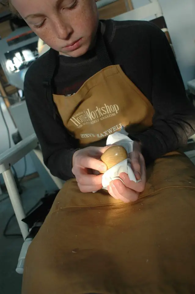 Our Joseph putting the final coat of wax on a wooden egg he carved in our workshop.