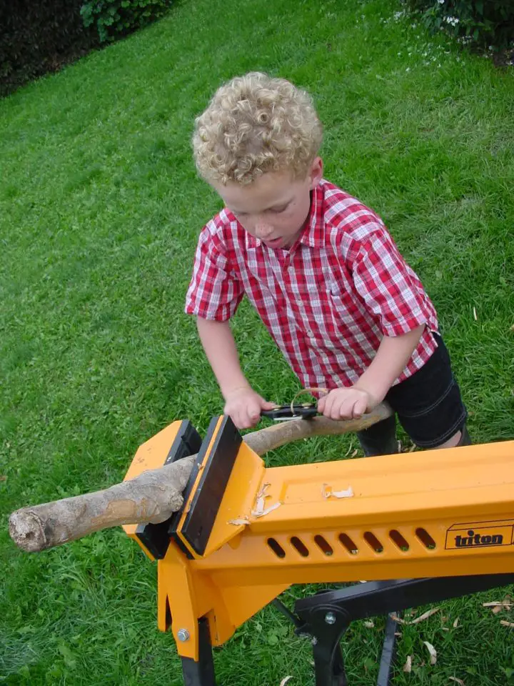 Spokshaves are safe, fun and creative tools that all kids love to use. Here Joseph, age four, is peeling bark off a tree branch with one. Some adult supervision is needed to adjust the tool and keep it working properly, but togetherness time is part of the deal.