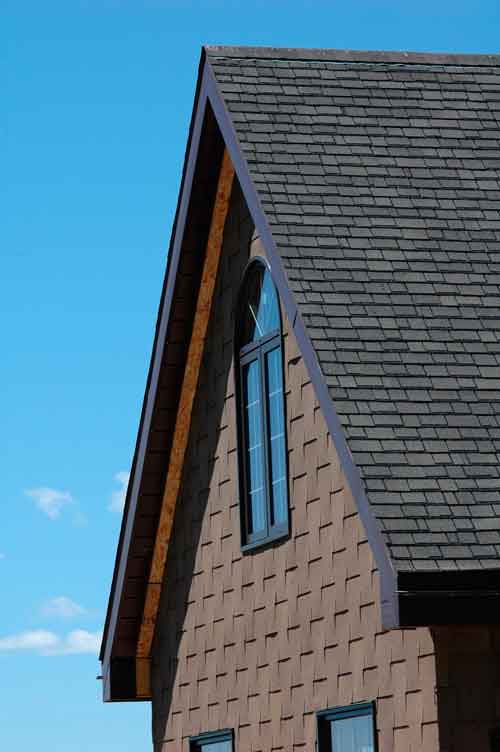 Aluminum soffit and fascia installed on a steep-roof building. The exposed wood behind the back edge of the soffit is to make room for brick veneer that will go up later.