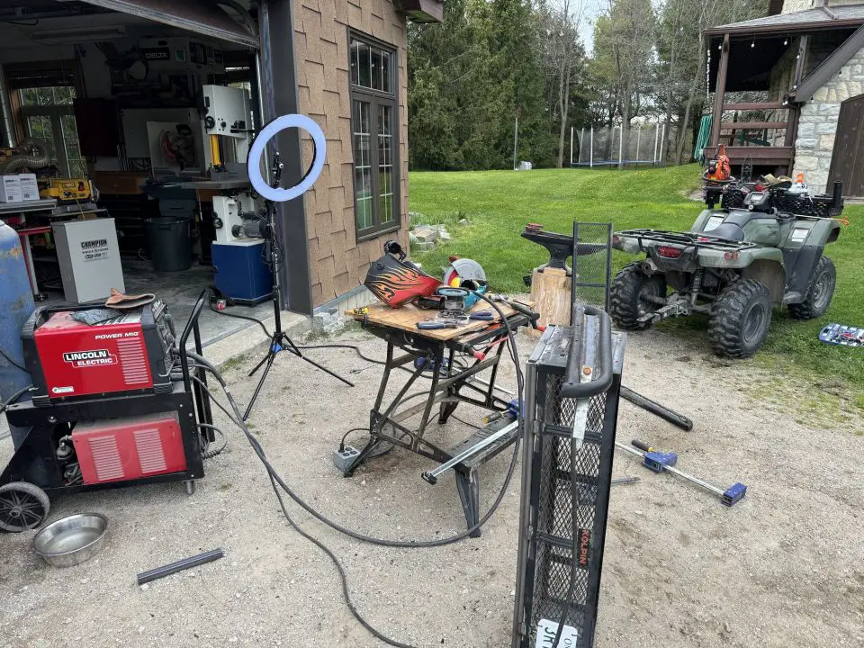 Outdoor workshop with equipment and an ATV.