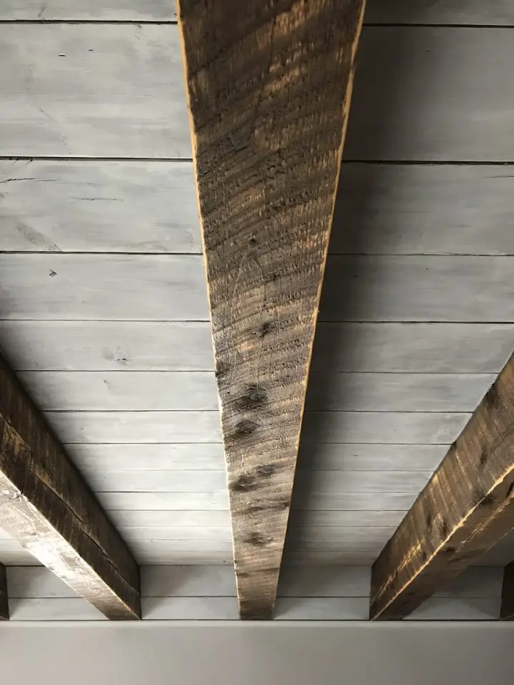 Rustic wooden beams on grey ceiling