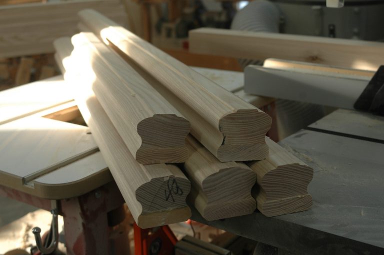 Stack of wooden moldings on a table saw.