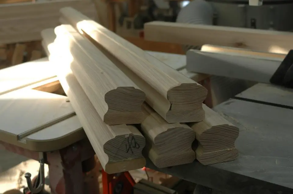 Stack of wooden moldings on a table saw.