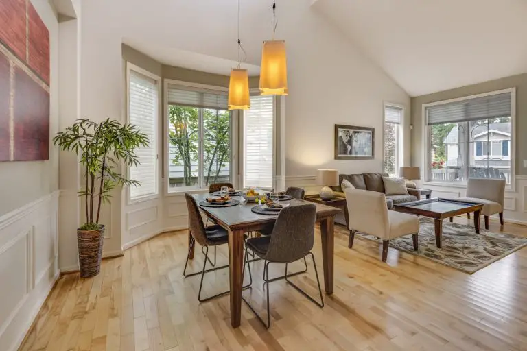 Modern living room with dining area and natural light.