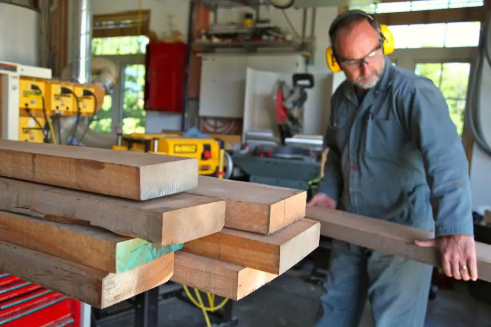 man carrying rough lumber