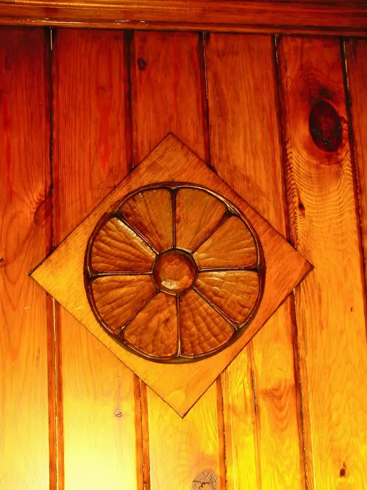 This carving on the front of our front door is in a piece of ordinary white pine that’s been inset into the tongue-and-groove red pine exterior.