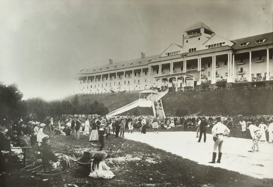 Historical hotel with people outside on the lawn.
